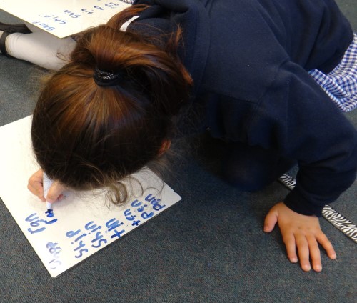 child spelling on whiteboard with marker